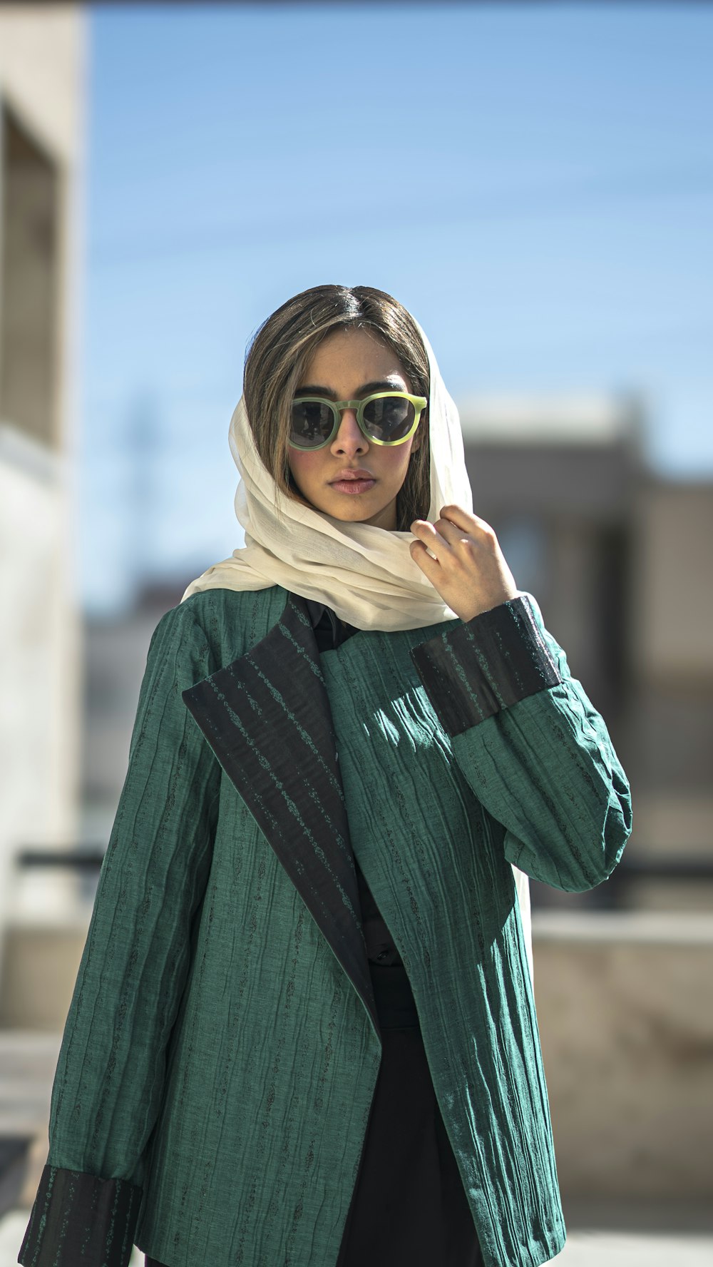 a woman wearing sunglasses and a green jacket