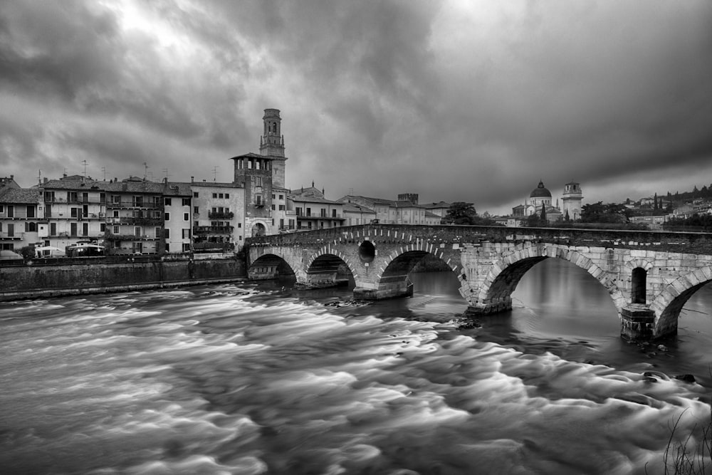 a black and white photo of a bridge over a river