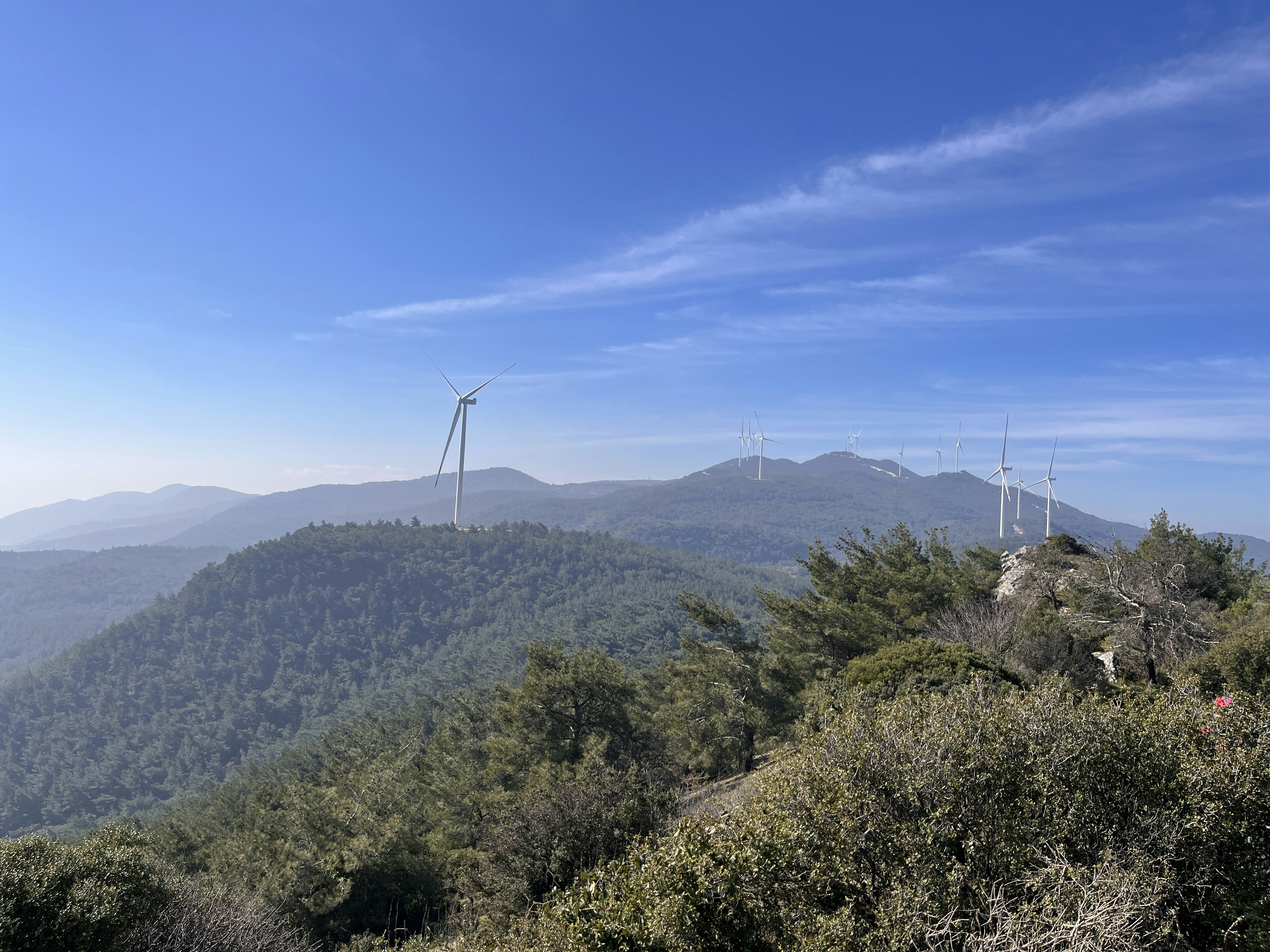 a view of a mountain with wind mills in the distance