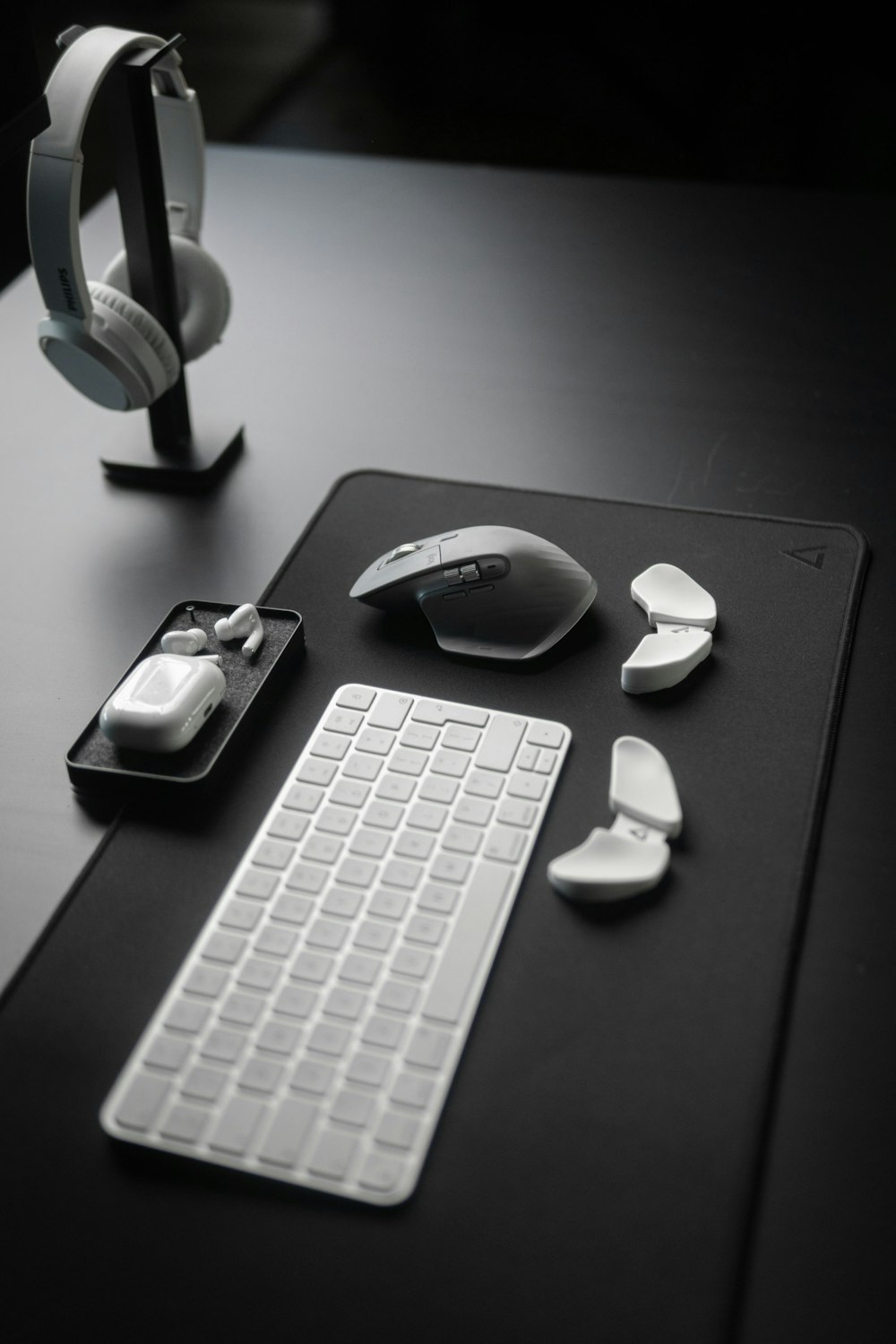 a desk with a keyboard, mouse and headphones on it