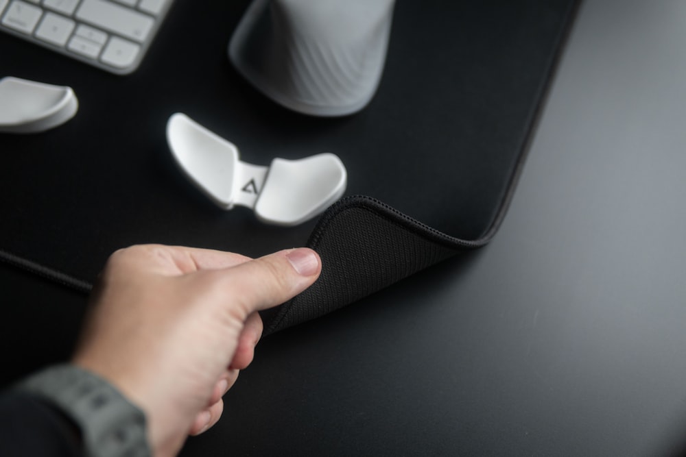 a person's hand on a mouse pad next to a keyboard