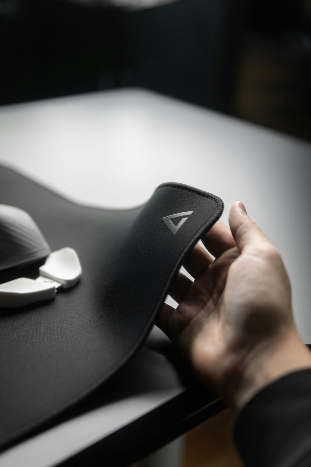 a person's hand on a mouse pad on a desk