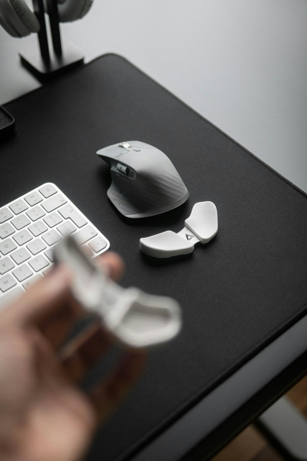 a person is holding a mouse near a keyboard and a mouse pad