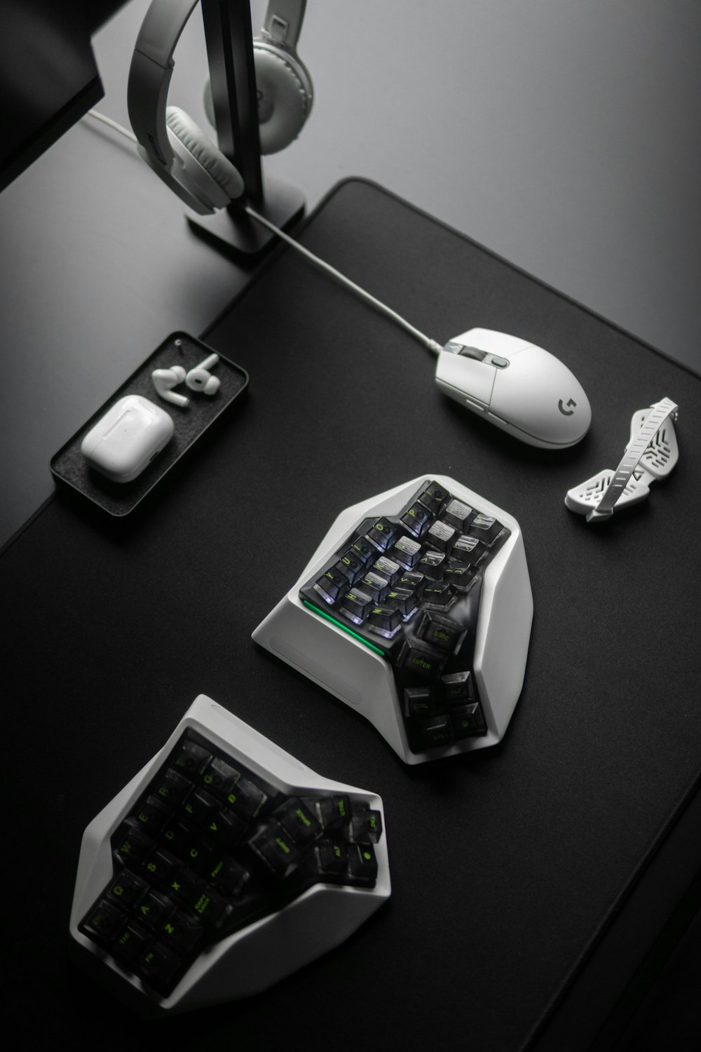 a desk with a keyboard, mouse and headphones on it