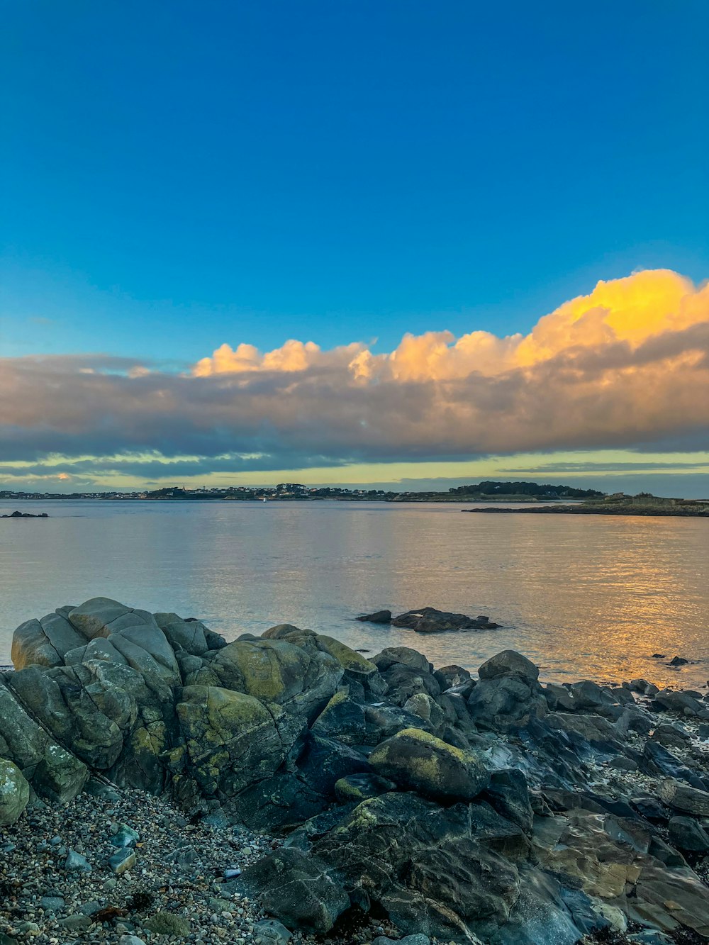 a view of a body of water with rocks in the foreground