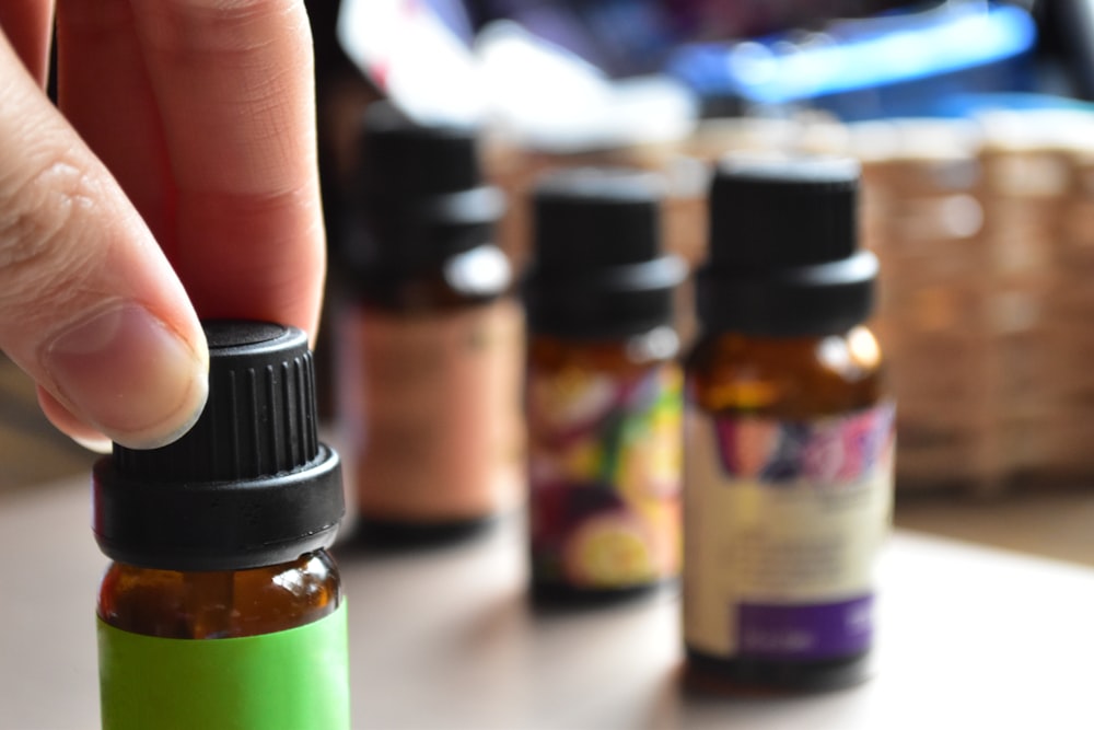 a hand touching a bottle of essential oils