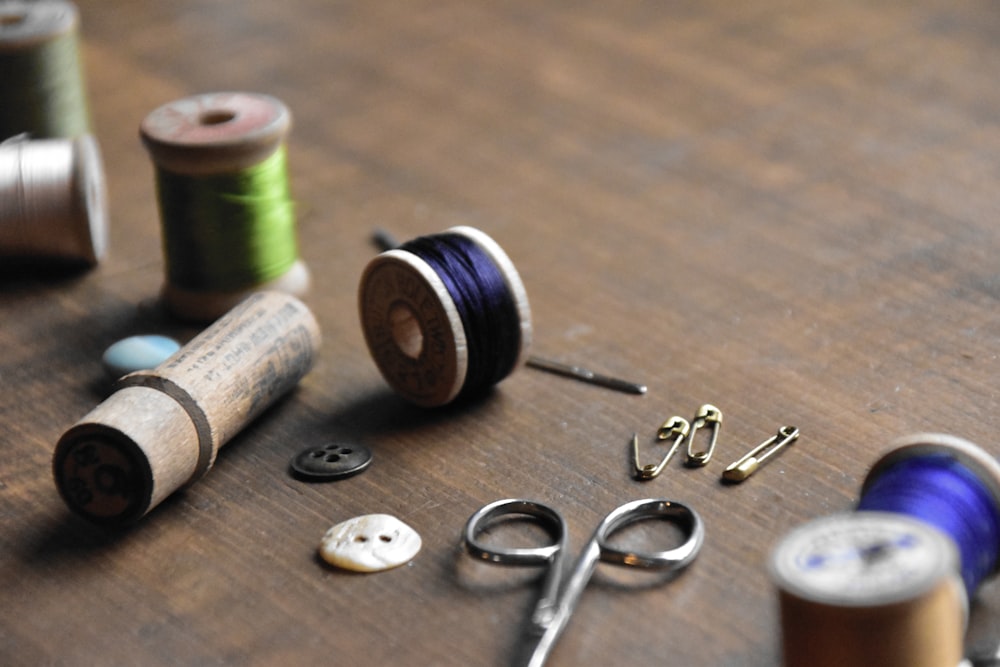 a wooden table topped with lots of sewing supplies