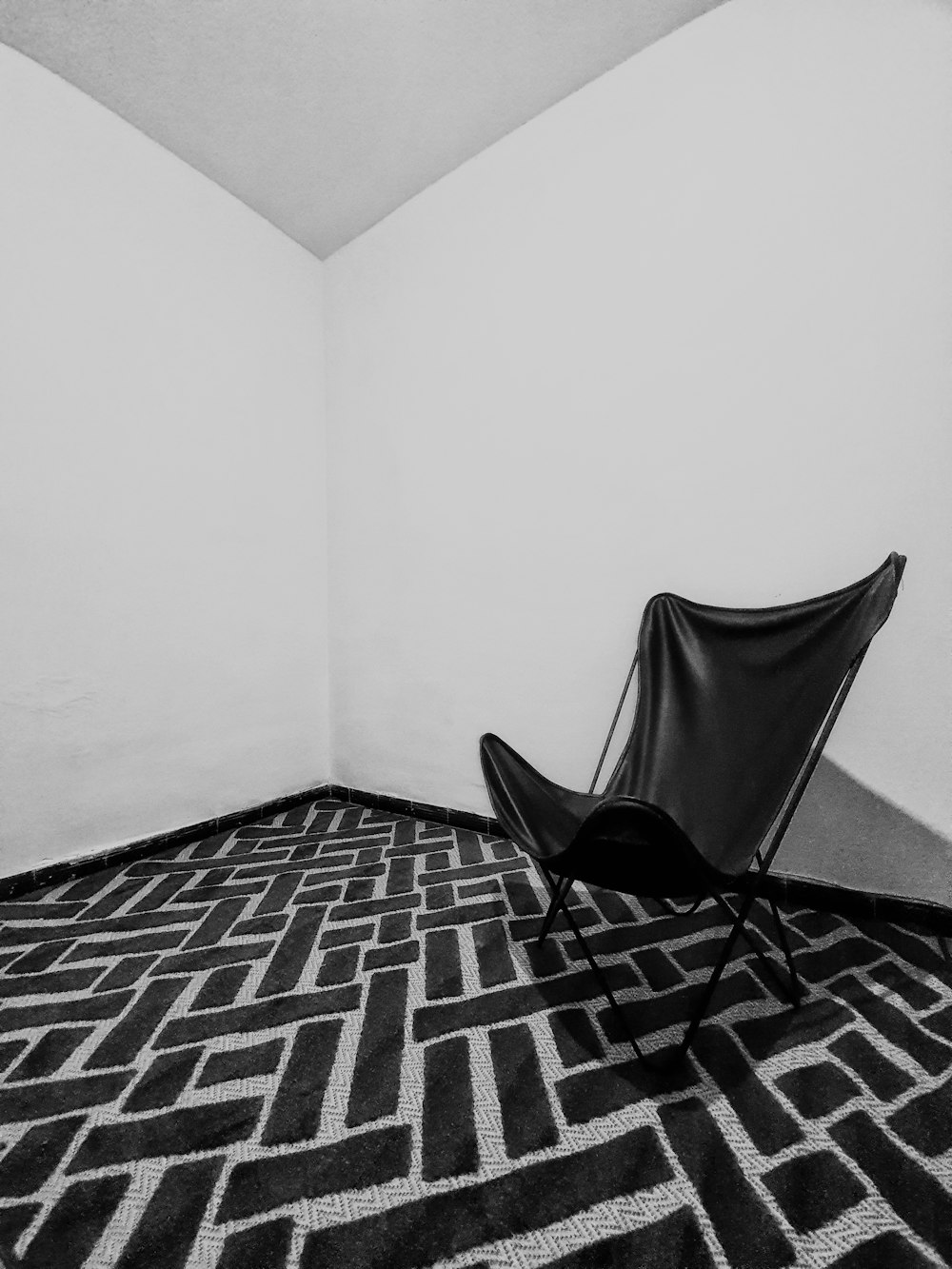a black chair sitting in a corner of a room