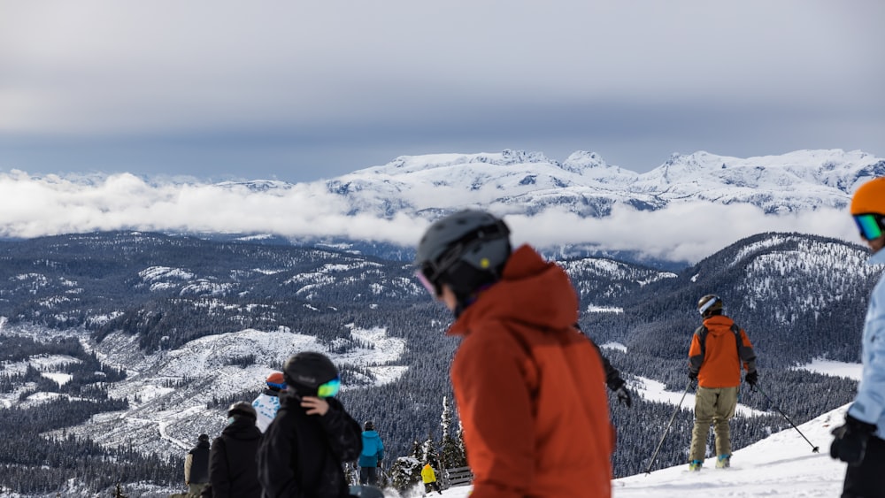 a group of people standing on top of a snow covered slope