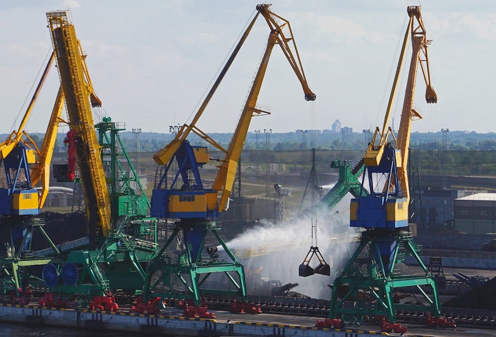 a group of cranes are spraying water onto a body of water
