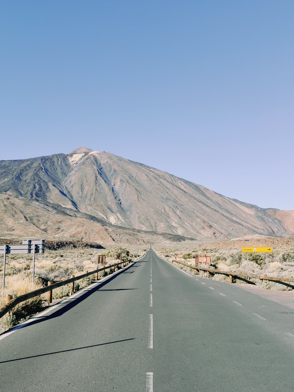 an empty road with a mountain in the background