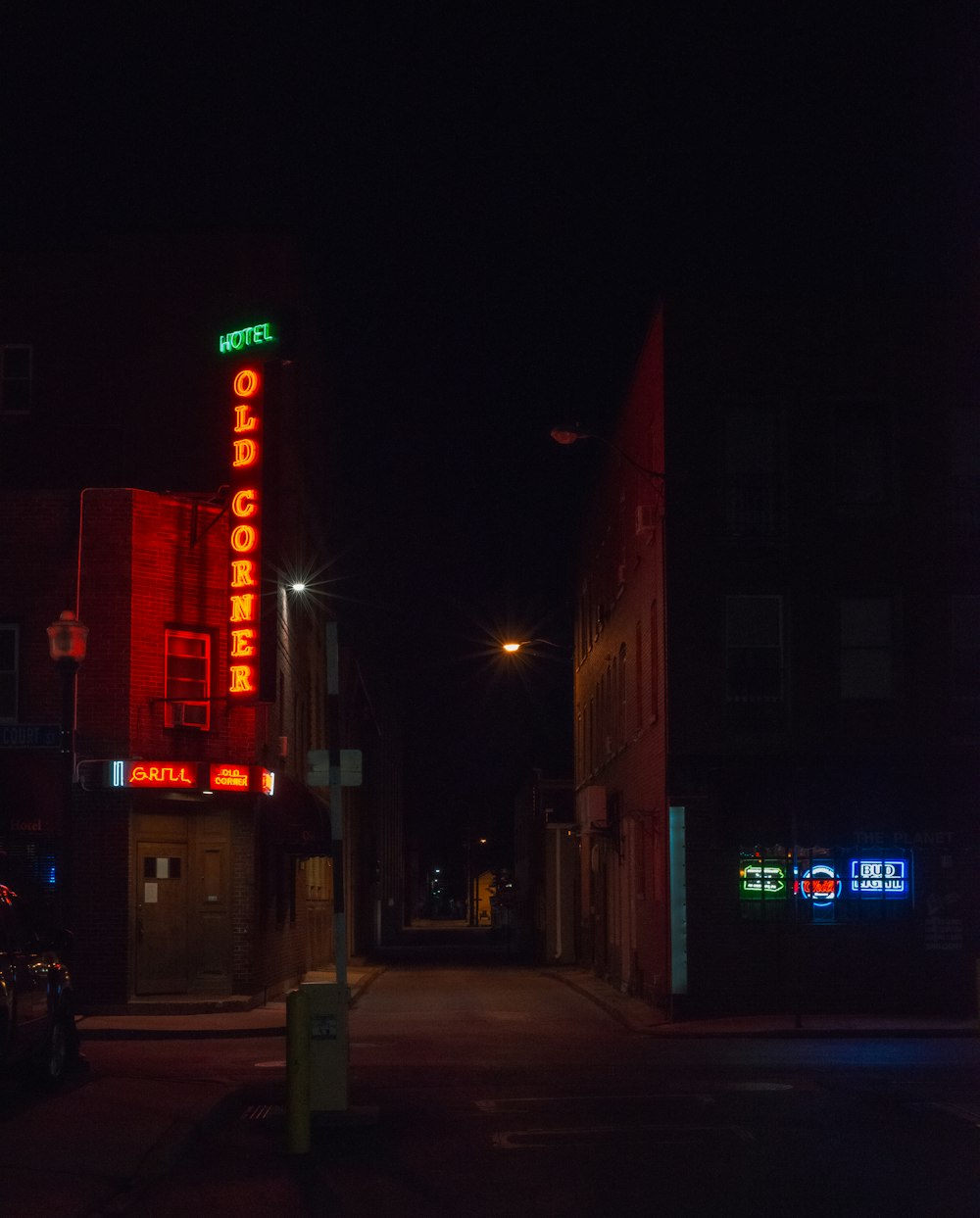 a city street at night with a neon sign