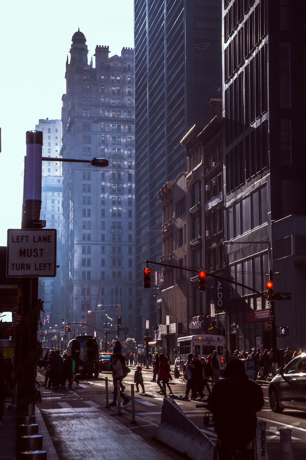 a group of people walking down a street next to tall buildings