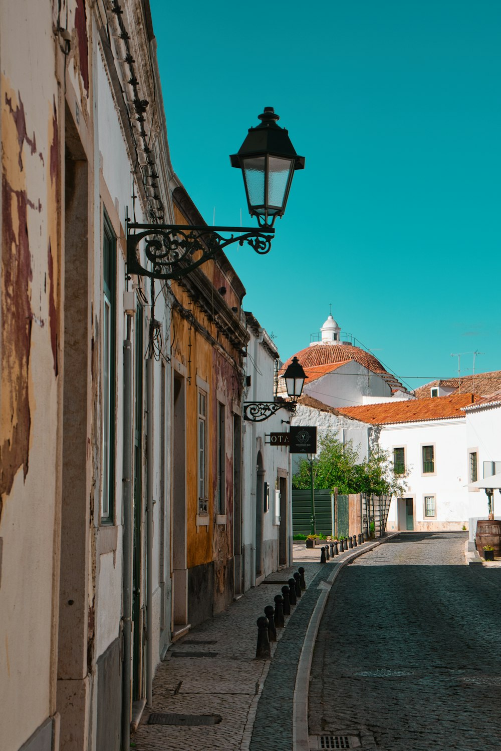 an empty street with a lamp on the side of it