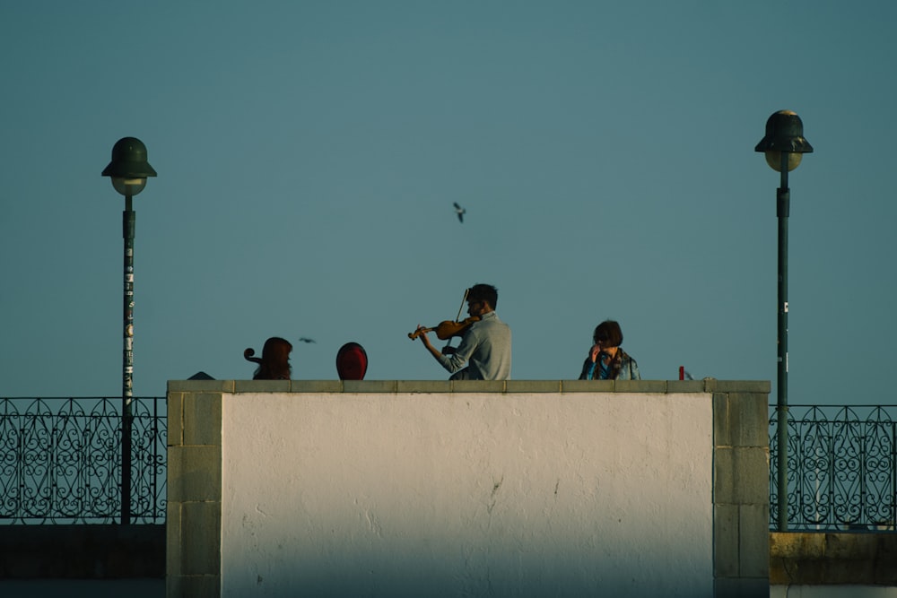 a group of people sitting on top of a building