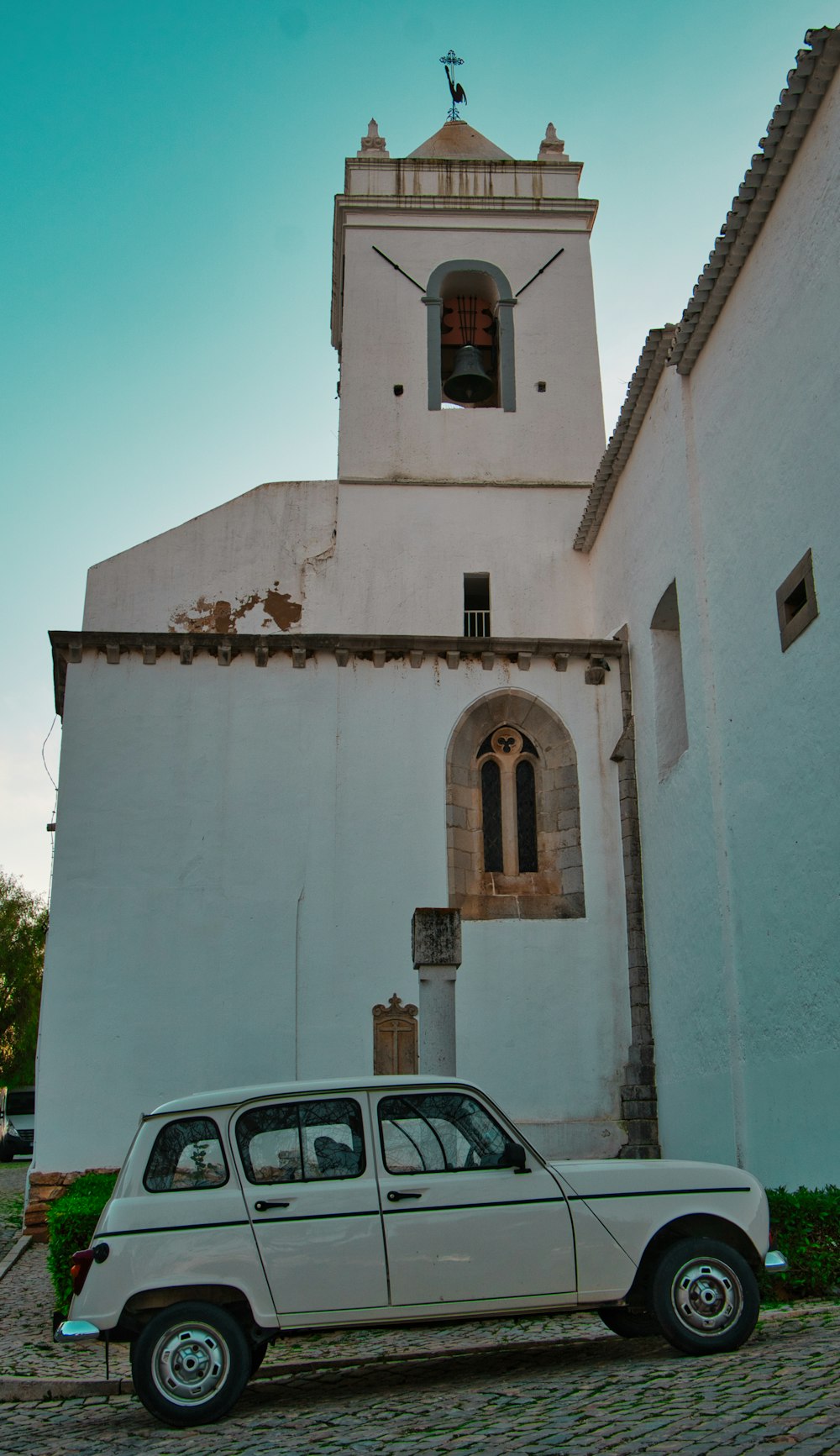 a white car parked in front of a church