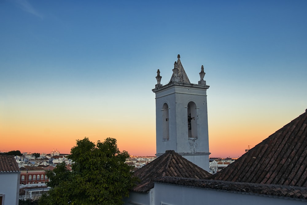 a tall white clock tower towering over a city