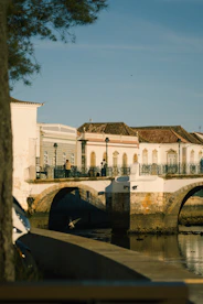 a bridge over a body of water with a building in the background