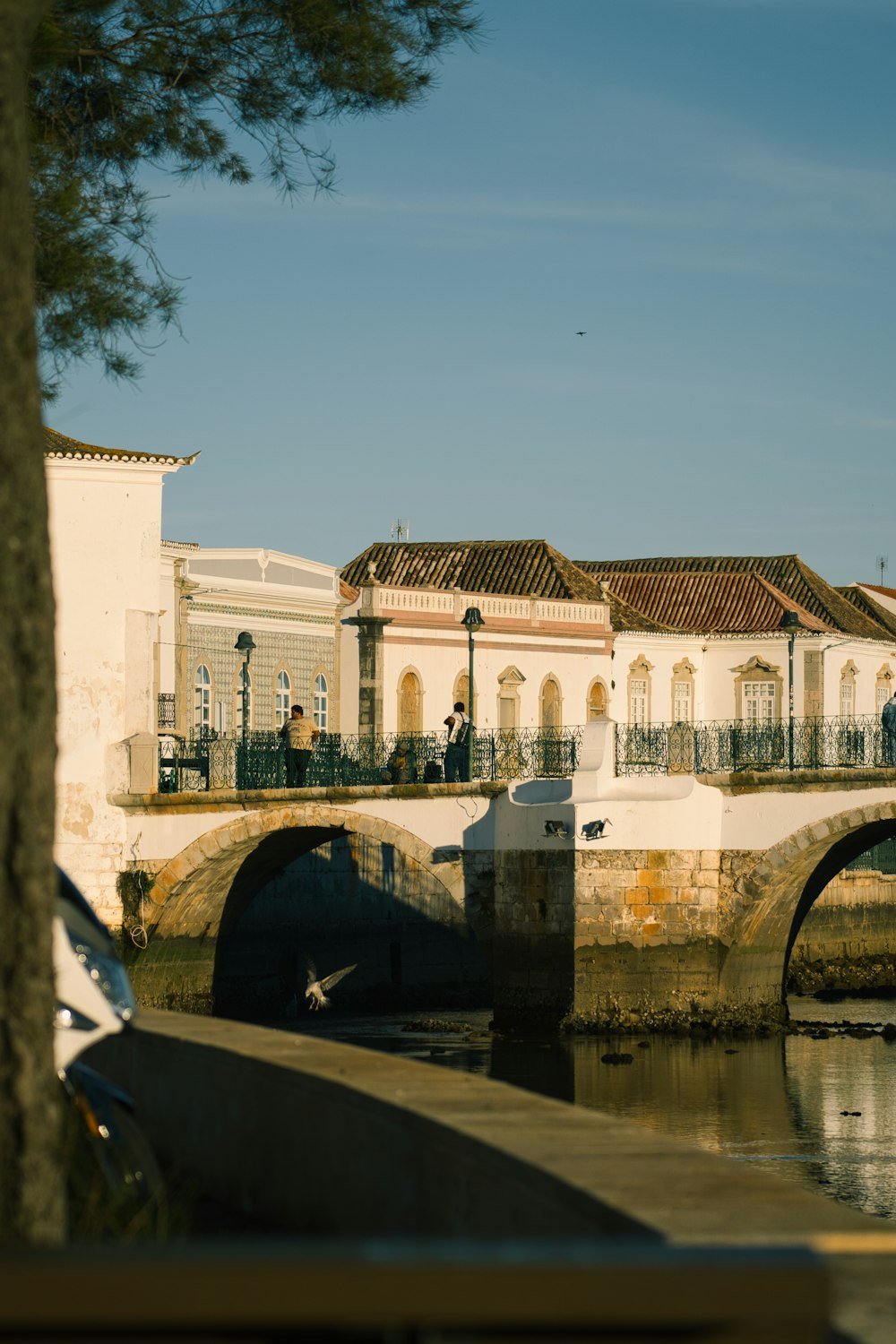 a bridge over a body of water with a building in the background