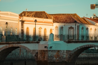 a bridge over a body of water with a building in the background
