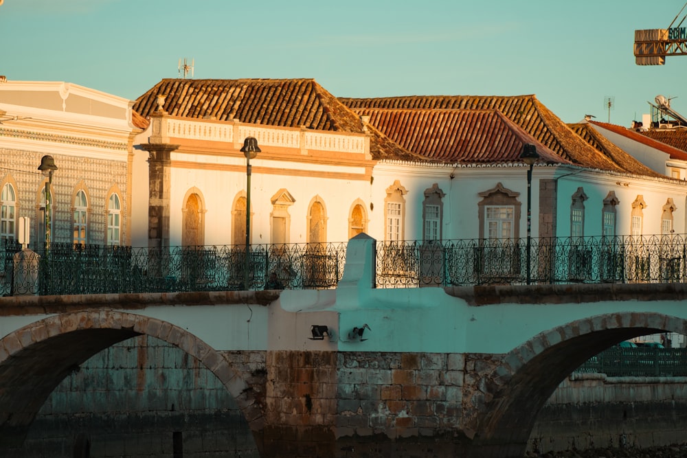 a bridge over a body of water with a building in the background