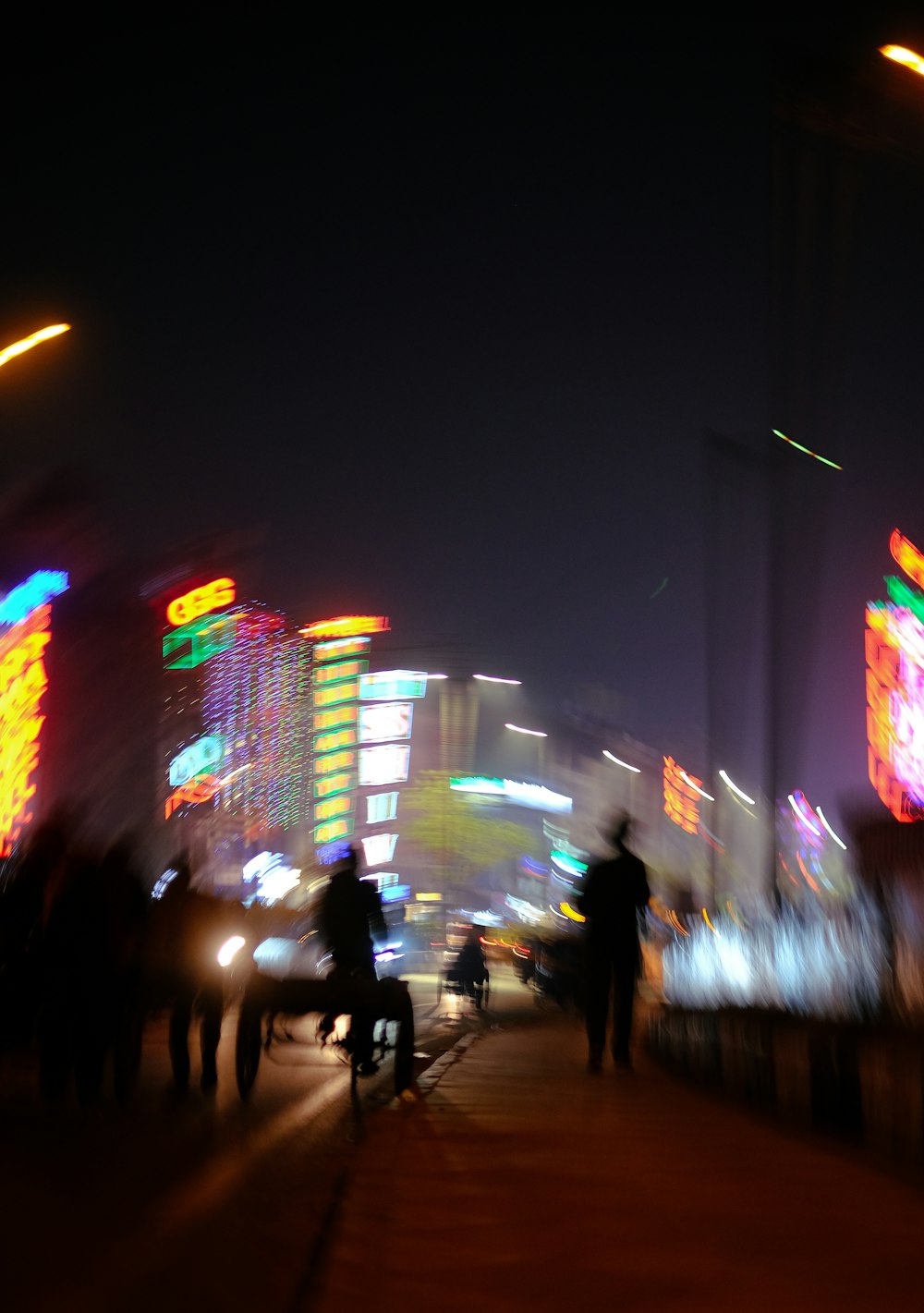 a group of people walking down a street at night