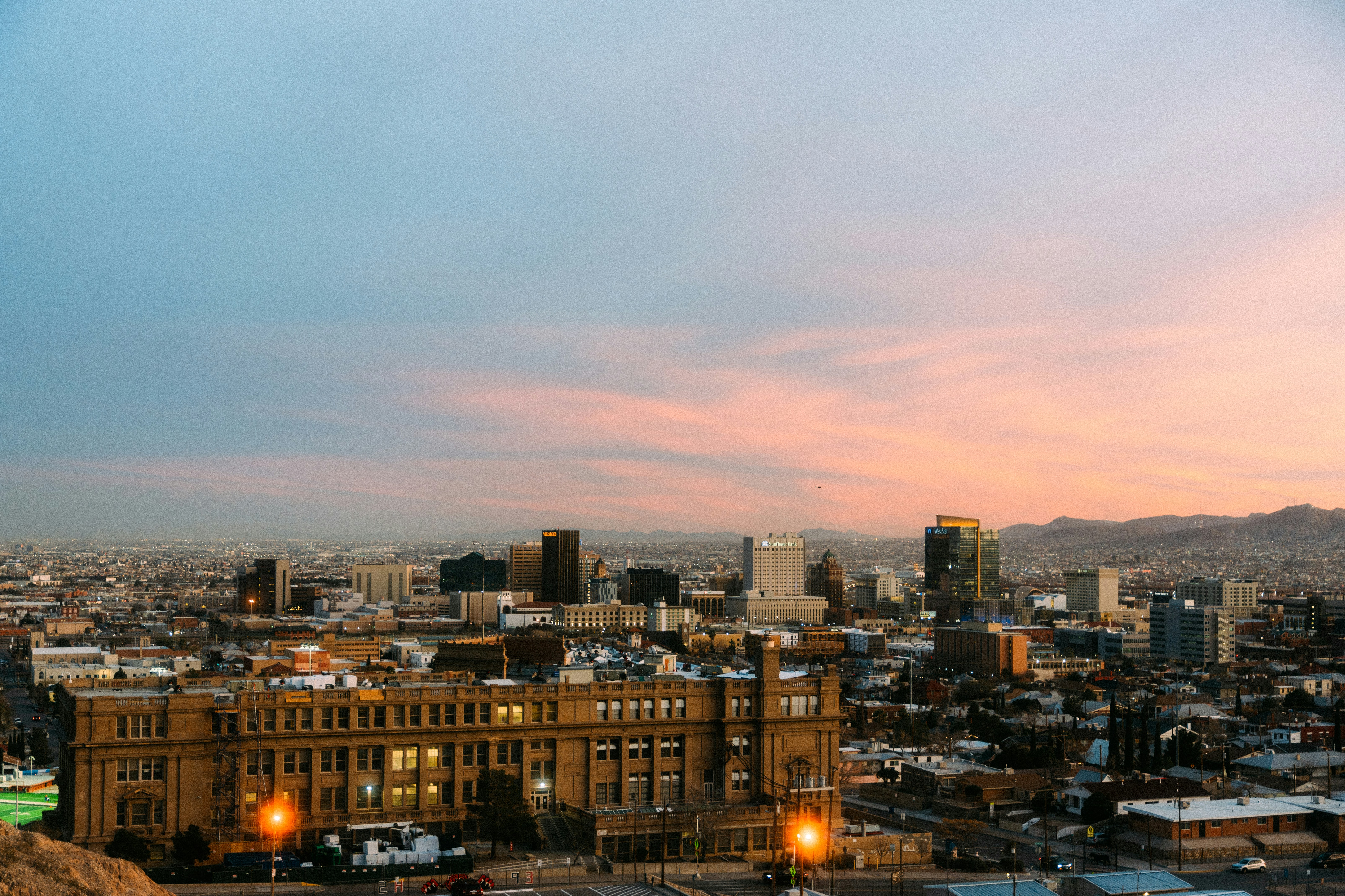 a view of a city at dusk from a hill