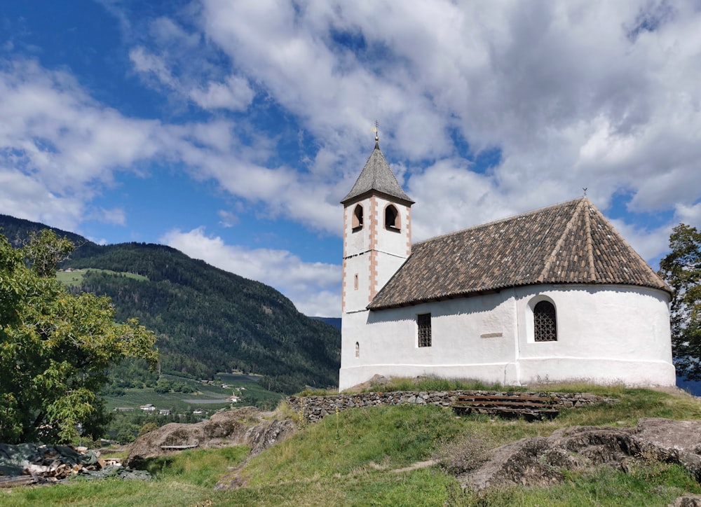 a white church with a brown roof on top of a hill