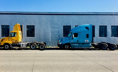 two semi trucks parked in front of a building