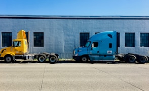 two semi trucks parked in front of a building