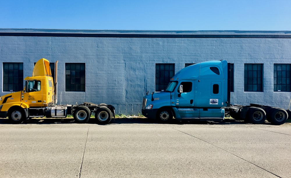 two semi trucks parked in front of a building