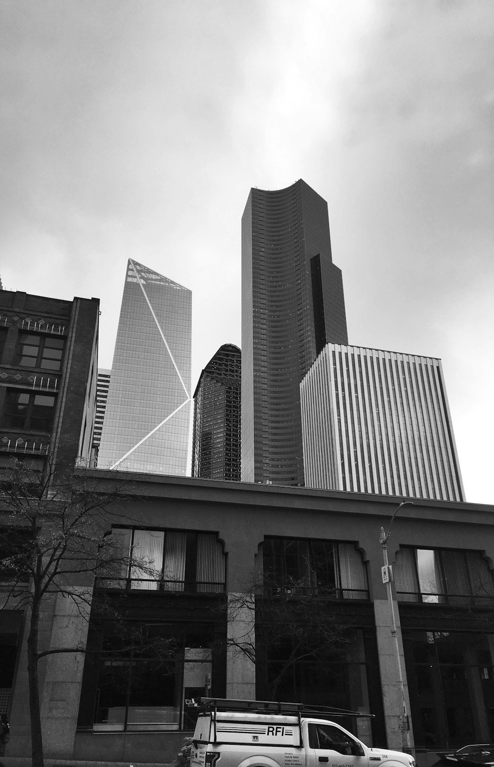 a black and white photo of a truck parked in front of a building