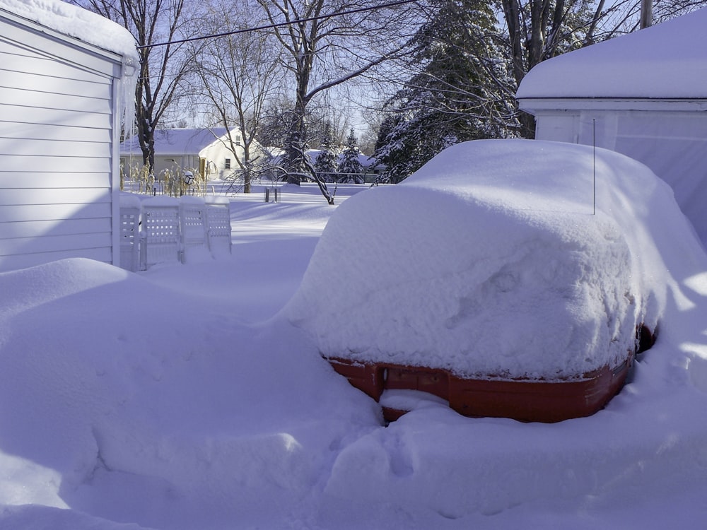 a car covered in snow in front of a house