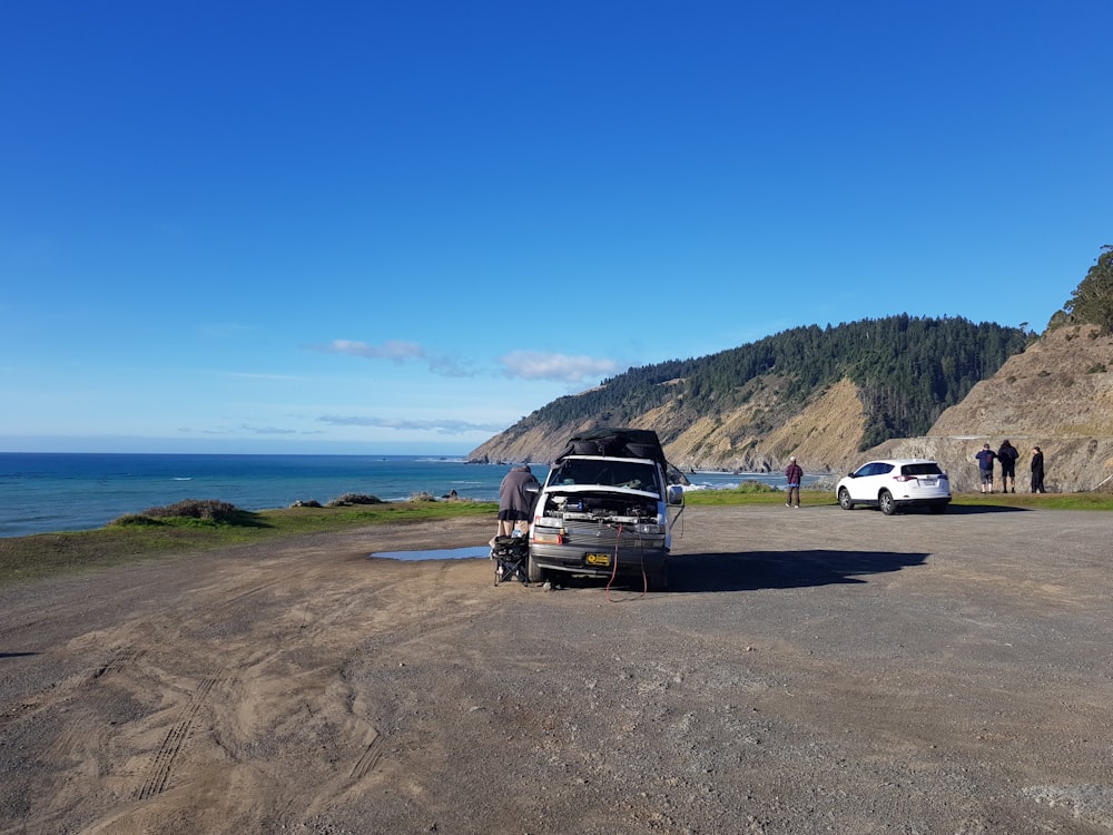 a truck parked on the side of a road next to the ocean