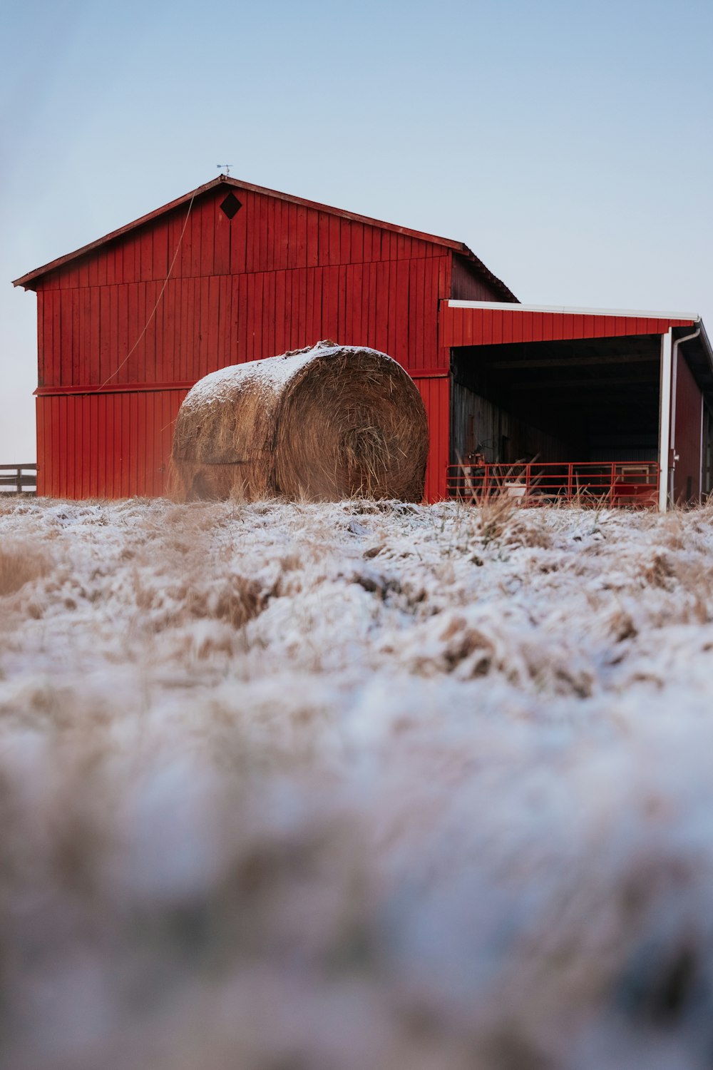 a red barn with hay bales in front of it
