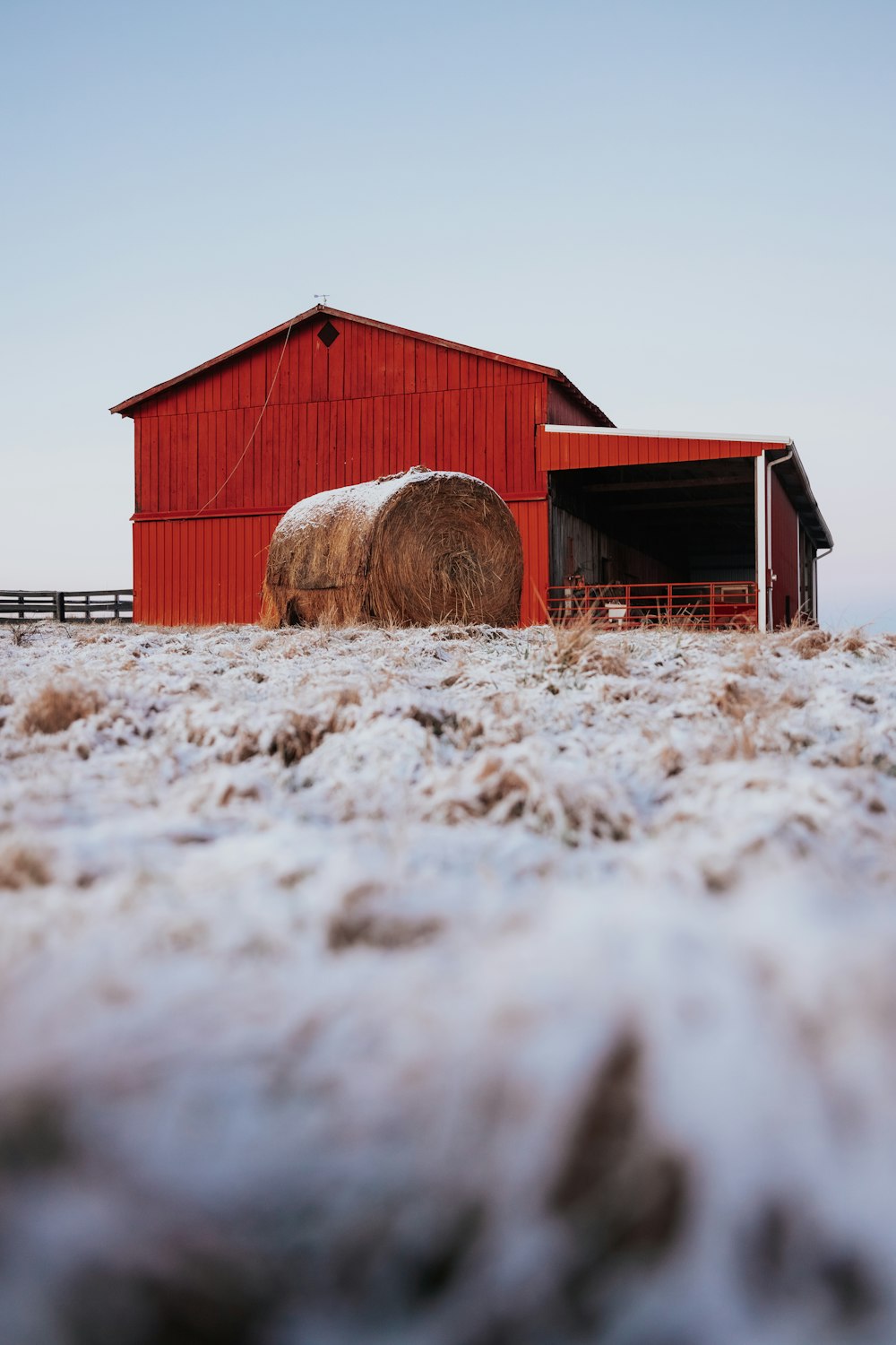 a barn with a hay bale in front of it