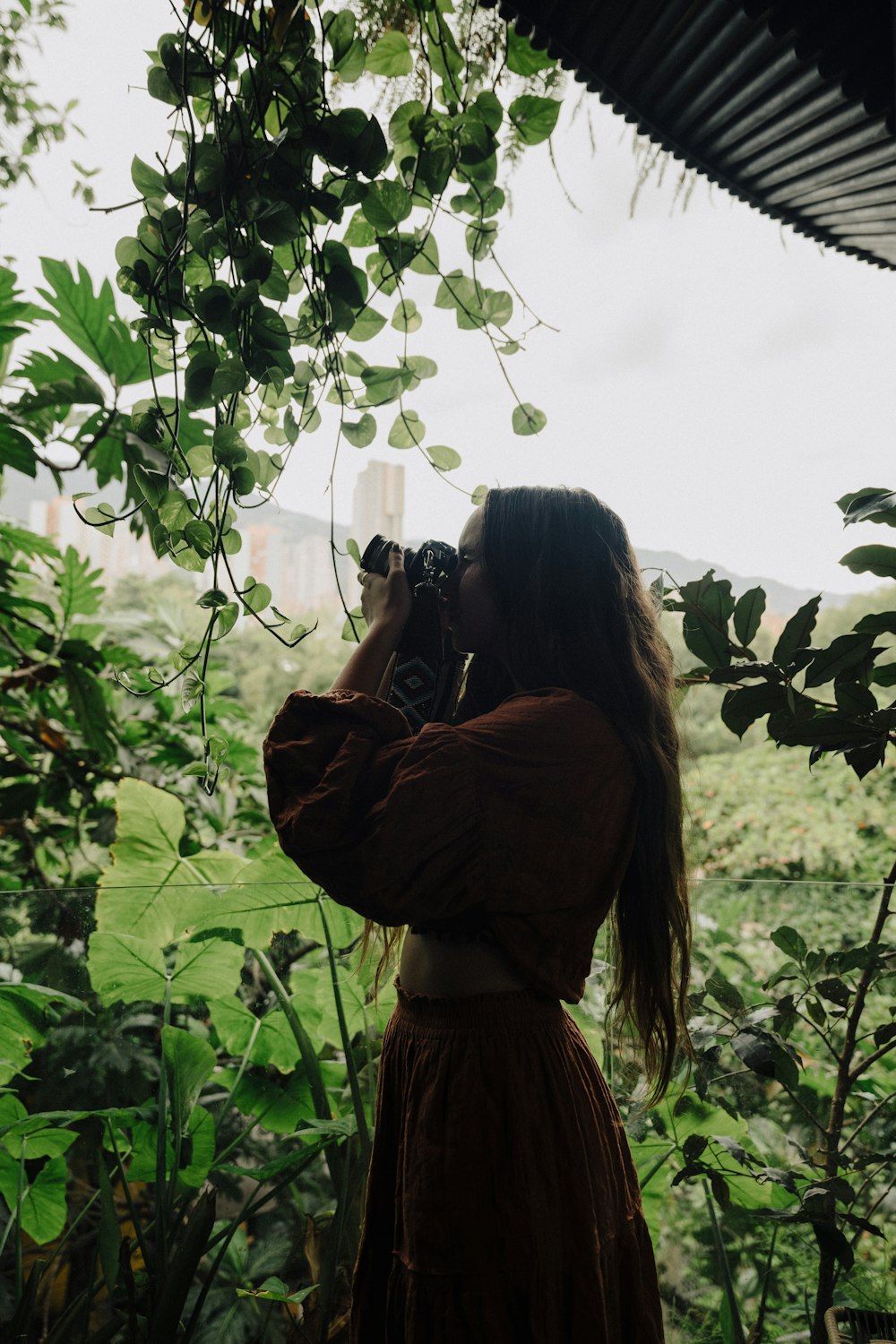 a woman in a brown dress is taking a picture