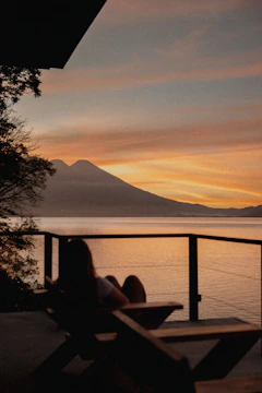 a person sitting on a bench looking out at the water