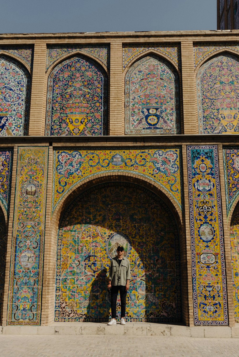 a person standing in front of a colorful building