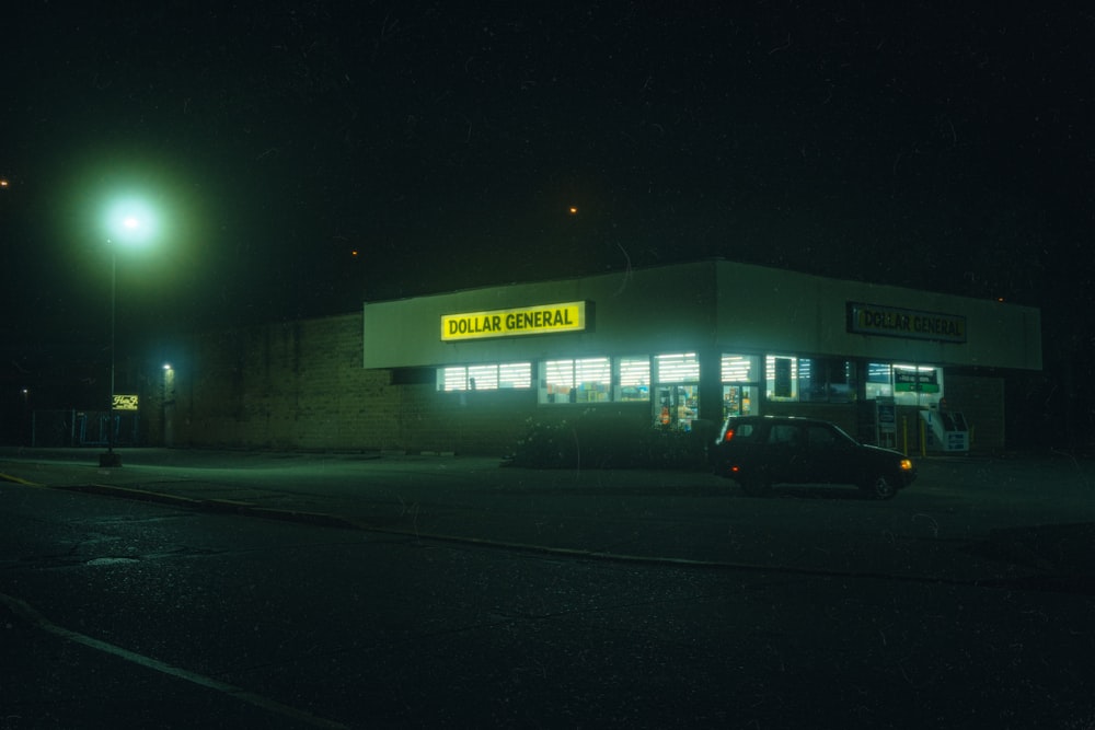 a car parked in front of a building at night