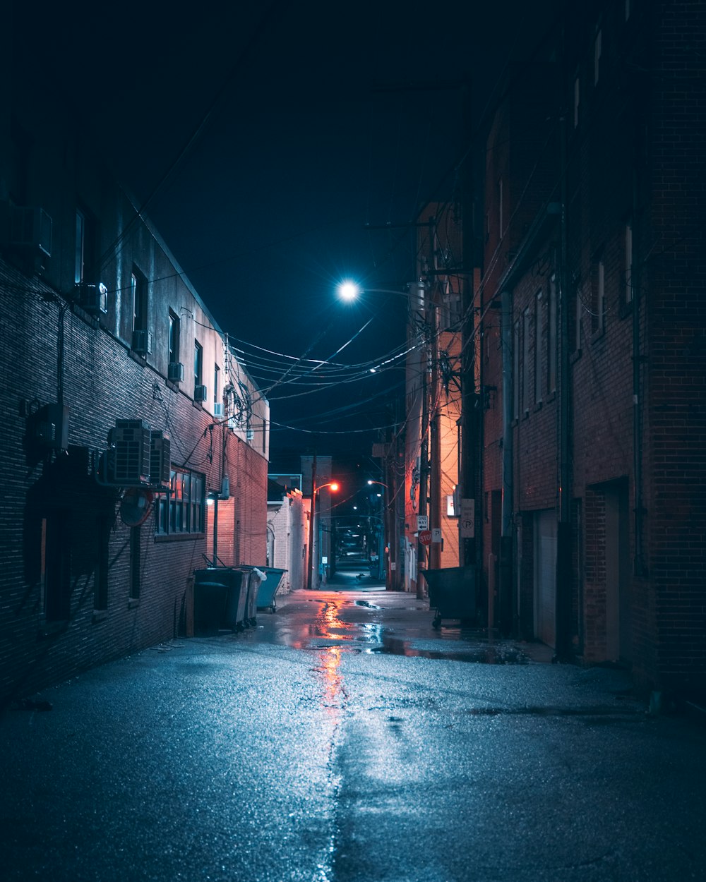 a dark alleyway with a street light at night