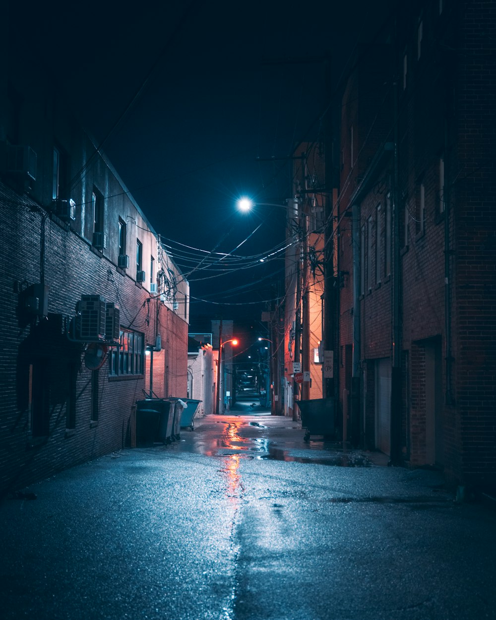 un callejón oscuro con una farola por la noche