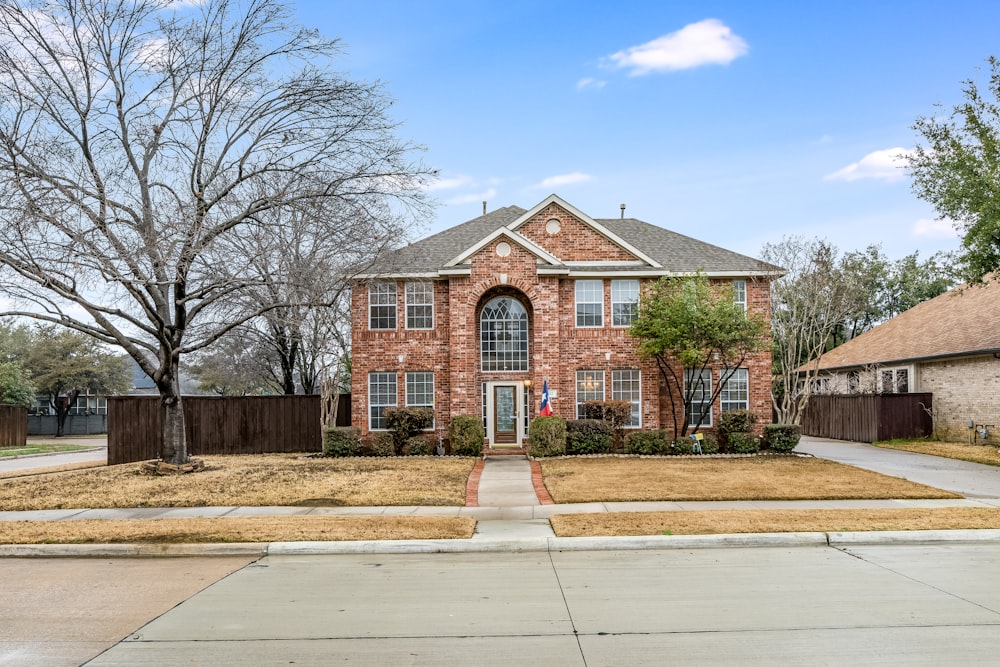 a brick house with a large front yard