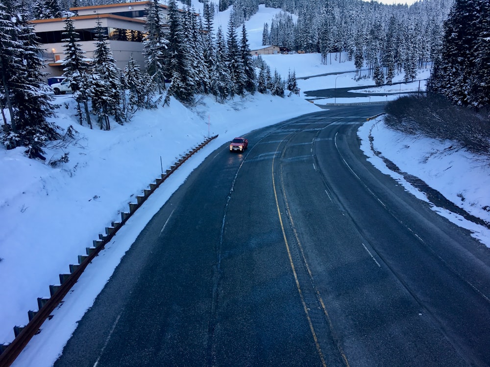 um carro está dirigindo por uma estrada nevada