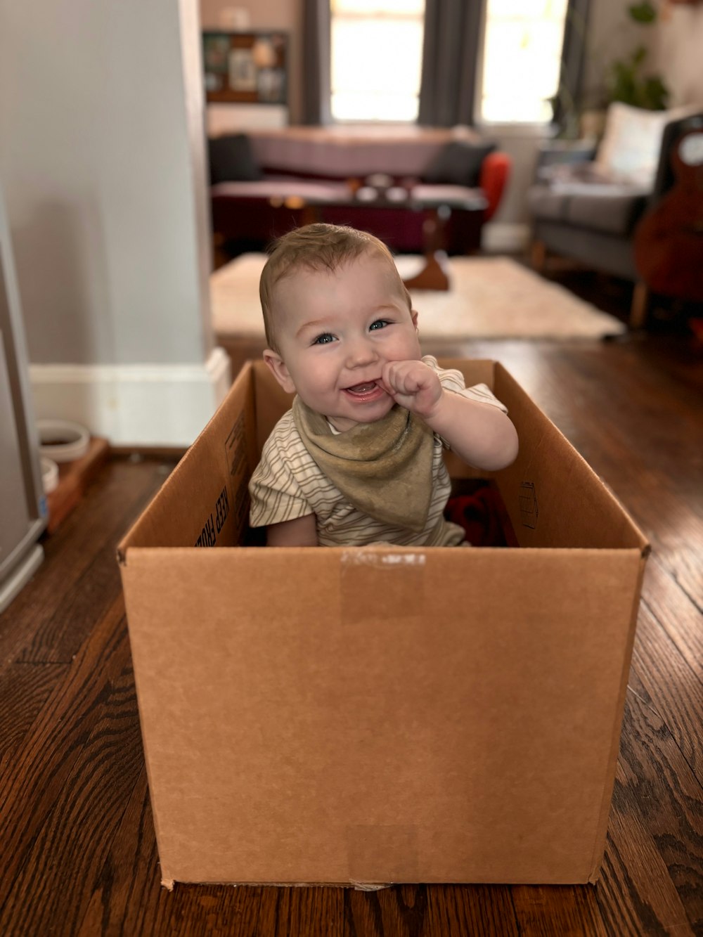 un bambino seduto all'interno di una scatola di cartone