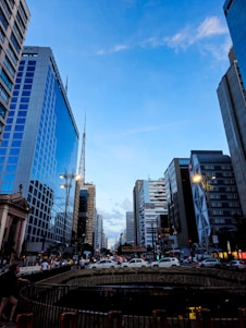 a city street with tall buildings and a bridge