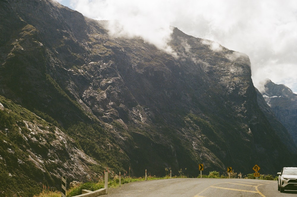 a white car driving down a mountain road