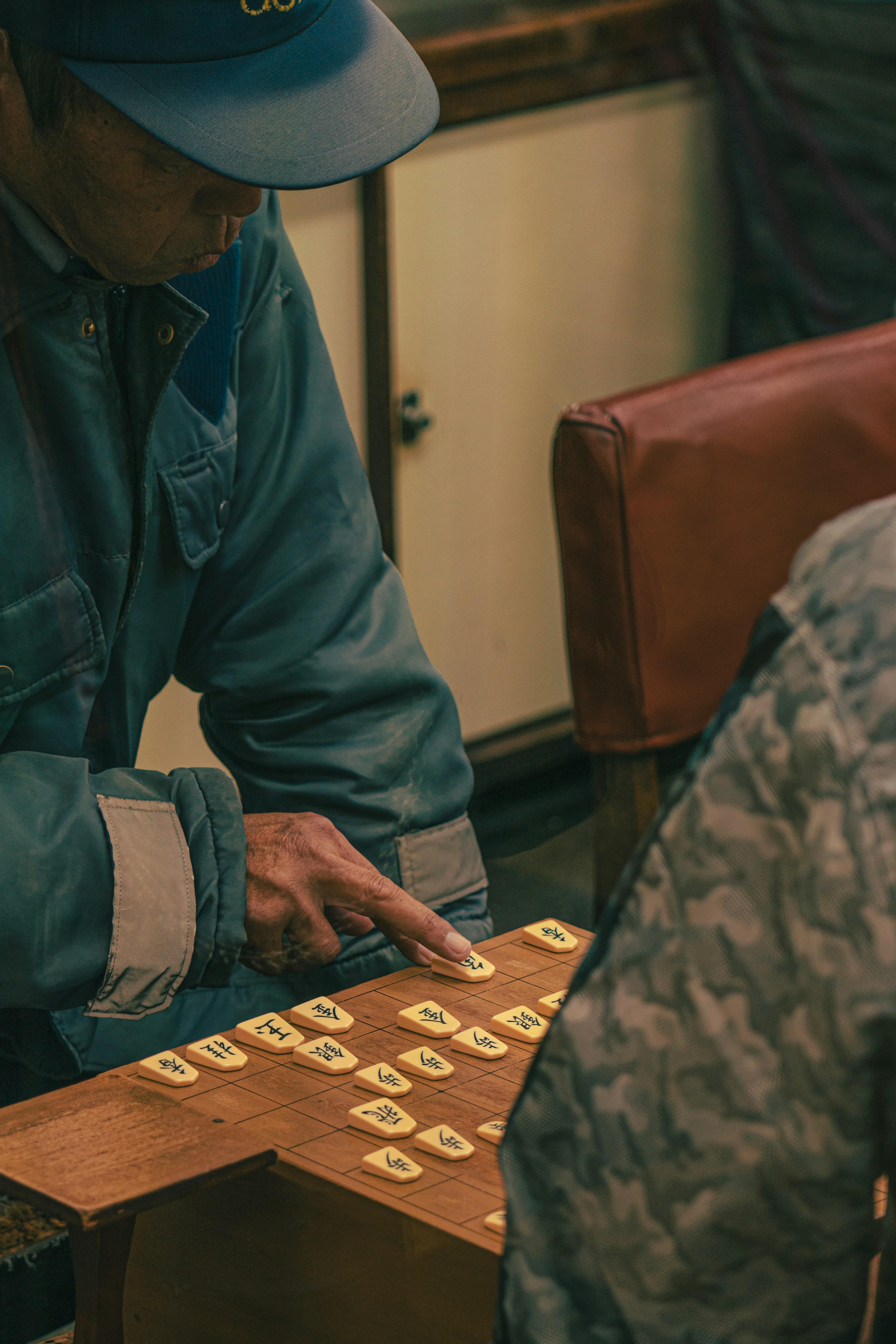 a man sitting at a table playing a game of checkers