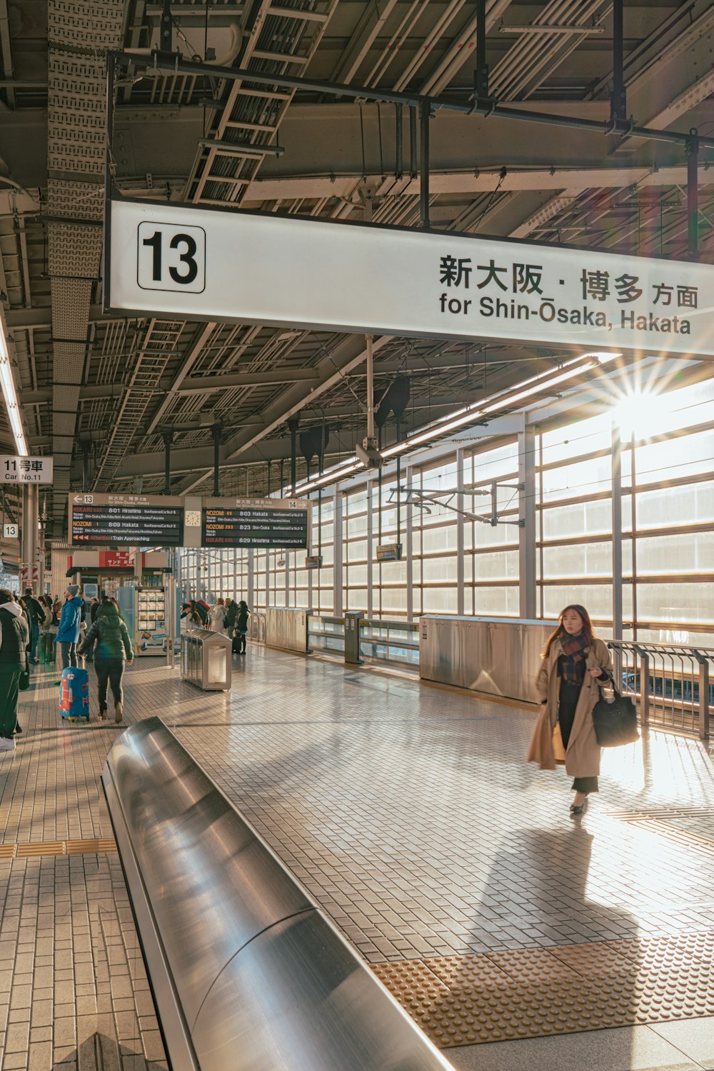 a woman with a suitcase walking through a train station