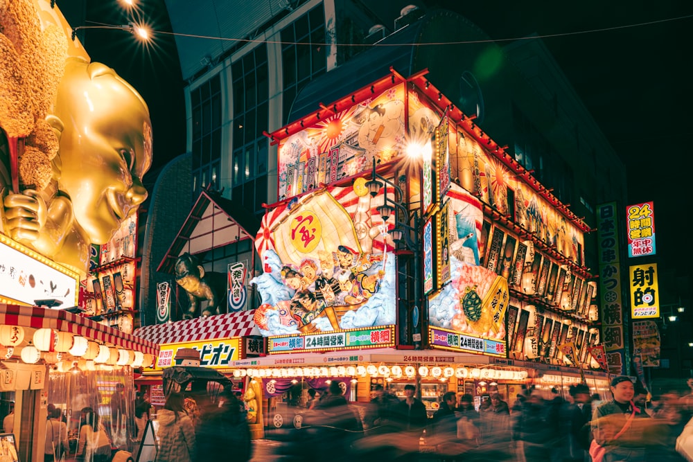 a crowd of people walking around a carnival at night